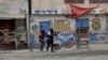 Oficiales de policía se refugian durante una operación antipandillas en el barrio Portail de Puerto Príncipe, la capital de Haití, el martes 25 de abril de 2023.
