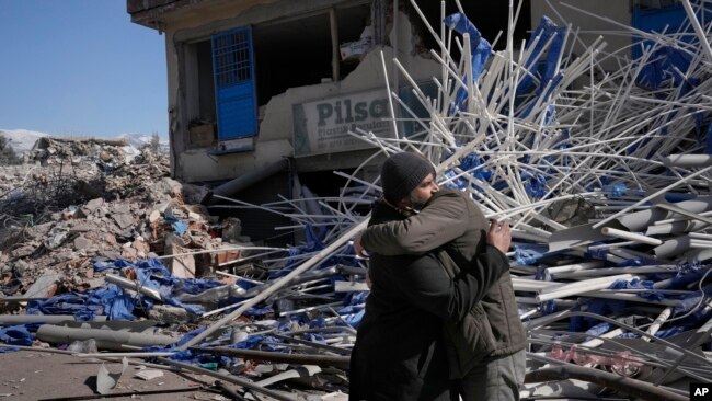 Syrian men comfort each other in Kahramanmaras, Turkey, Feb. 15, 2023.