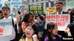 Environmental activists Choi Jia and Kim Hannah chant slogans during a press conference before the initial hearing for petitions. April 23, 2024. (REUTERS/Kim Hong-Ji)