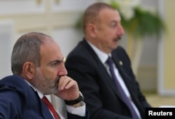 FILE - Armenia's Prime Minister Nikol Pashinyan and Azerbaijan's President Ilham Aliyev attend a meeting in Ashgabat, Turkmenistan, Oct. 11, 2019.