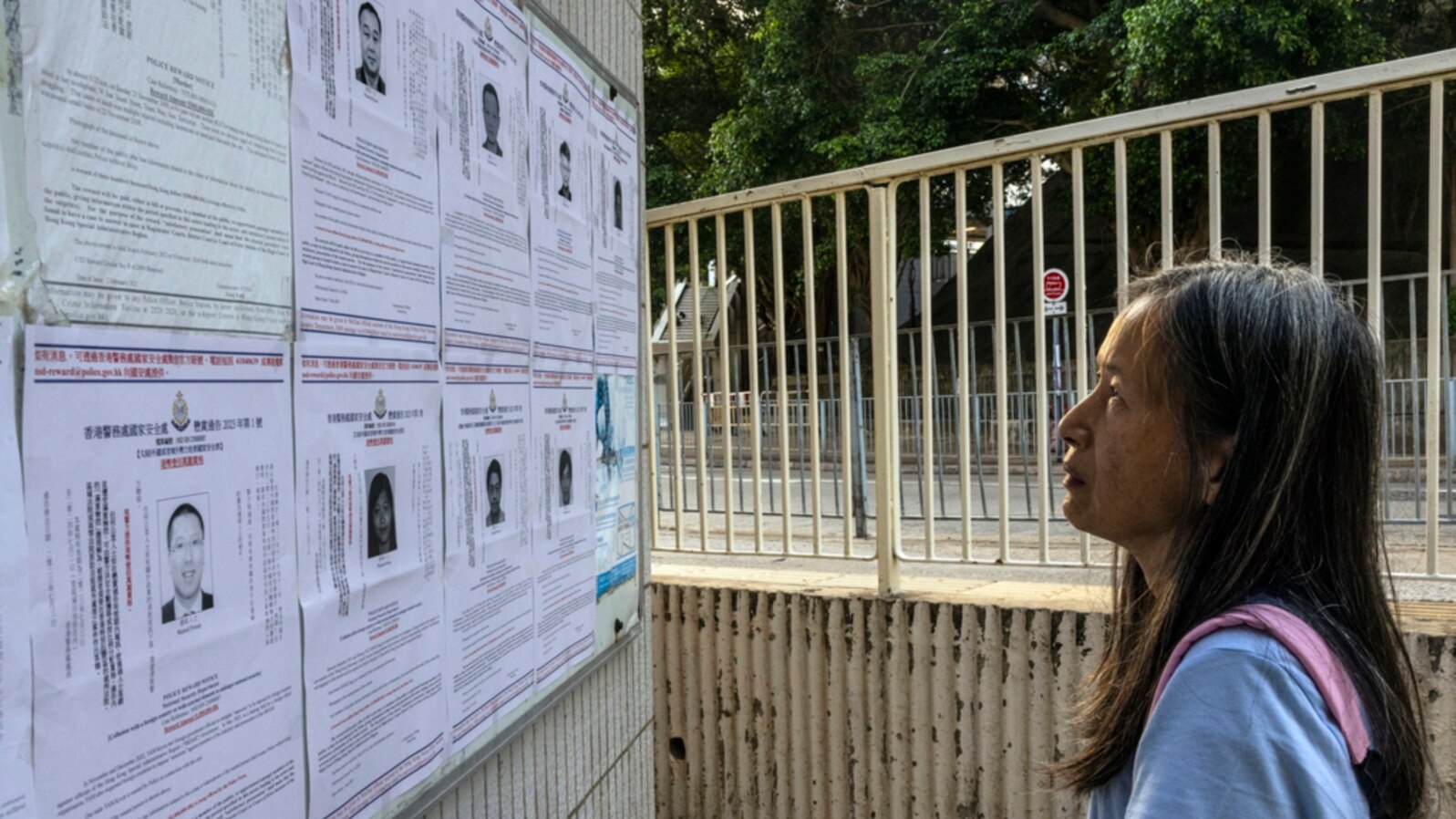 FILE - A pedestrian looks at the police reward notices for the arrest warrants issued for pro-democracy activists living in the United States, Britain, Canada and Australia for alleged national security offenses in Hong Kong, July 14, 2023. 