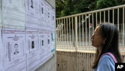 FILE - A pedestrian looks at the police reward notices for the arrest warrants issued for pro-democracy activists living in the United States, Britain, Canada and Australia for alleged national security offenses in Hong Kong, July 14, 2023. 