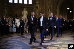 Prime Minister Sir Keir Starmer (left) and Conservative leader Rishi Sunak (right) lead MPs through the Central Lobby at the Palace of Westminster ahead of the State Opening of Parliament in London, July 17, 2024