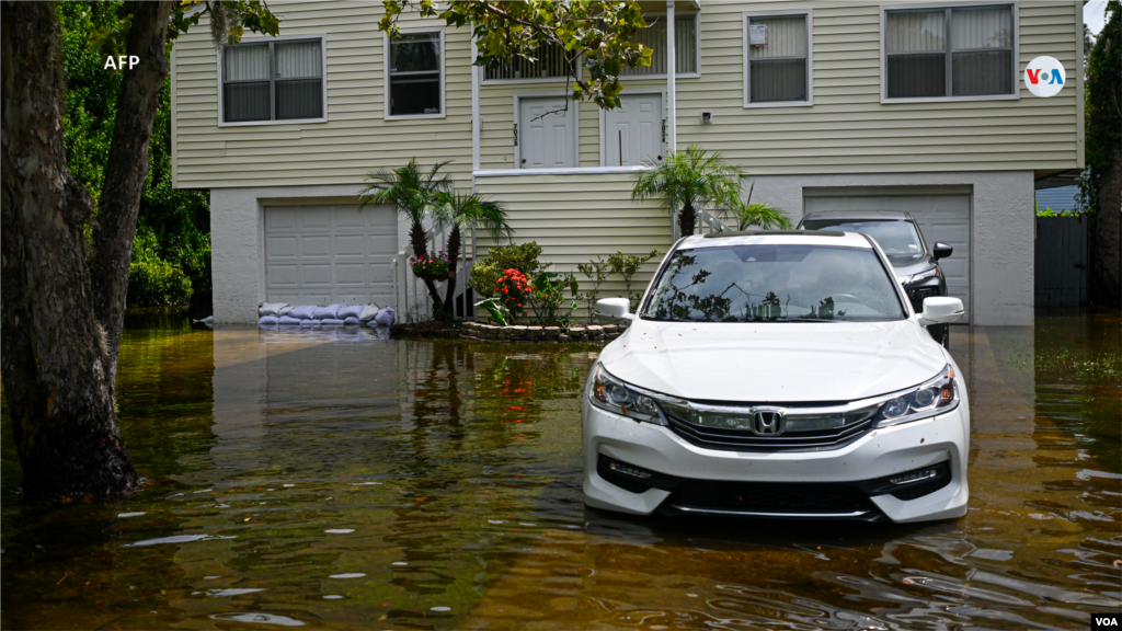 Un vehículo frente a una casa inundada en New Port Richey, Florida.