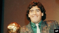 FILE - Argentinian soccer star Diego Maradona holds his Golden Ball trophy during a ceremony in Paris, France, Nov. 13, 1986.