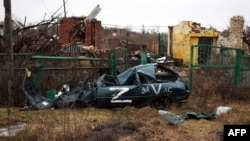 Uništeno vozilo označeno znakom "Z" koji predstavlja agresiju Rusije na Ukrajinu i zgrade srušene kao rezultat granatiranja vide se u selu Kamenka, u ukrajinskoj oblasti Harkov, 26. februara 2023. godine.