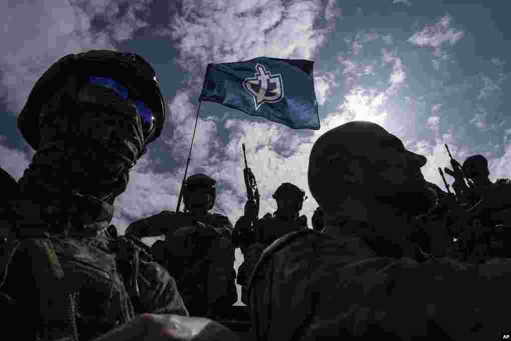 Fighters of Russian Volunteer Corps stand atop on an APC during a press conference not far from the border in Sumy region, Ukraine.