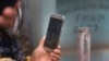 ARCHIVO - Una mujer con un celular, el 19 de julio en las afueras de Lima, Perú, el miércoles 17 de junio de 2020.