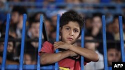 A youth watches from the stands during the final match of a local football tournament at the municipal stadium in Idlib, Syria, Aug. 18, 2023.