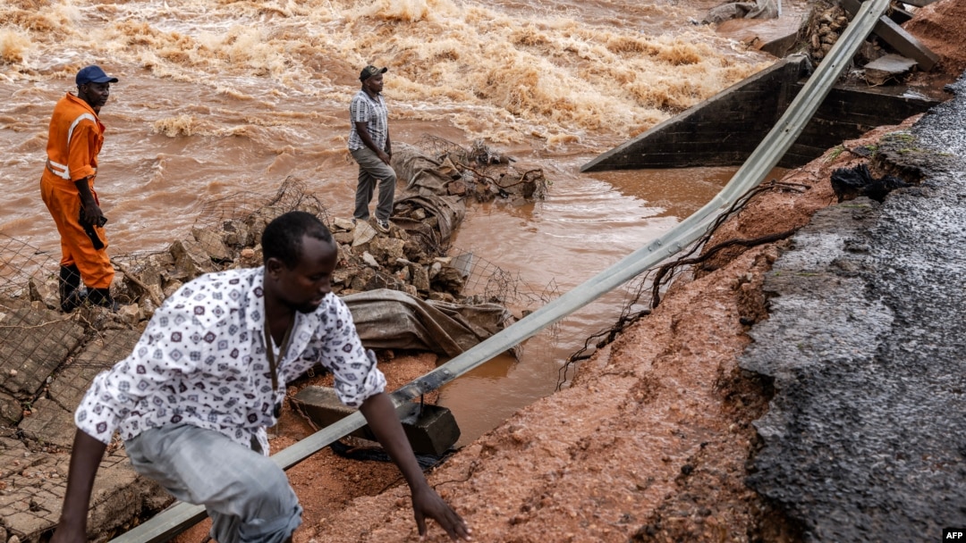 FILE - Men gather to asses the damage in the section of a road collapsing due to flash floods at the Mwingi-Garissa Road near Garissa, Kenya, on Nov. 22, 2023. 