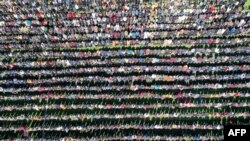 In this image from above, Muslims perform the &quot;rain prayer&quot; inside a stadium in the Syrian rebel-held northwestern city of Idlib, Syria.