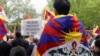FILE - Protesters wearing Tibetan flags on their shoulders take part in a demonstration in support of members of the Tibetan and Uyghur community and against the Chinese President's two-day state visit to France, at Place de la Republique in Paris, May 5, 2024. 