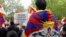 FILE - Protesters wearing Tibetan flags on their shoulders take part in a demonstration in support of members of the Tibetan and Uyghur community and against the Chinese President's two-day state visit to France, at Place de la Republique in Paris, May 5, 2024. 