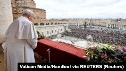 Paus Fransiskus berdiri saat menyampaikan pesan tradisional Hari Natal Urbi et Orbi dari balkon utama Basilika Santo Petrus di Vatikan, 25 Desember 2023. (Foto: Media Vatikan/Handout via REUTERS)