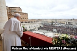 Paus Fransiskus berdiri saat menyampaikan pesan tradisional Hari Natal Urbi et Orbi kepada kota dan dunia dari balkon utama Basilika Santo Petrus di Vatikan, 25 Desember 2023. (Foto: Media Vatikan/Handout via REUTERS)