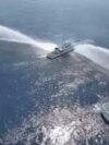 In this image made from video provided by the Philippine Coast Guard, a Philippine Coast Guard vessel is water cannoned by the Chinese Coast Guard as it tries to approach the waters near Scarborough Shoal in the South China Sea on April 30, 2024. 