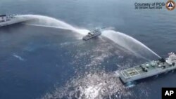 In this image made from video provided by the Philippine Coast Guard, a Philippine Coast Guard vessel is water cannoned by the Chinese Coast Guard as it tries to approach the waters near Scarborough Shoal in the South China Sea on April 30, 2024. 