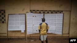 FILE - A Gabonese voter checks the registry at a polling station in the Rio district during the presidential Election on August 27, 2016 in Libreville. 