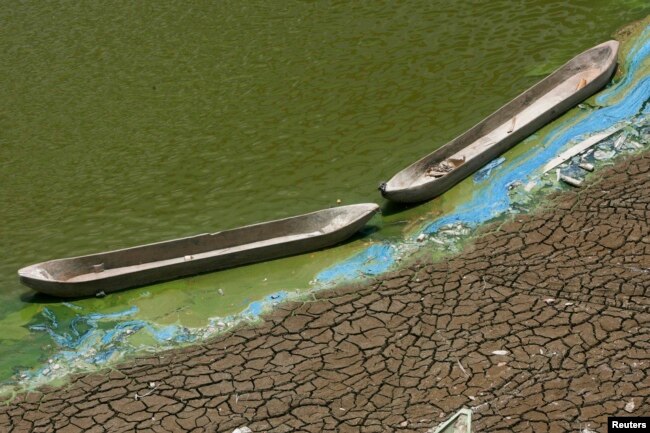 FILE - Perahu kayu terdampar di dasar waduk Pacal yang mengering akibat musim kemarau panjang, di desa Kedung Sumber, dekat Bojonegoro, provinsi Jawa Timur, 16 Oktober 2013. (REUTERS/Sigit Pamungkas)
