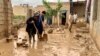 Warga tampak membersihkan lumpur dari halaman rumah mereka setelah banjir melanda wilayah Maymana, ibu kota dari provinsi Faryab di Afghanistan, pada 19 Mei 2024. (Foto: Reuters/Stringer)