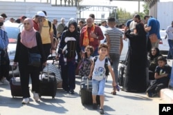 Palestinci čekaju na graničnom prelazu Rafa između Pojasa Gaze i Egiptskog pojasa Gaze 14. oktobra 2023.