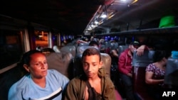 FILE - Migrants are seen on board a bus that will take them to the border between Nicaragua and Honduras at a bus terminal in Managua, on Oct. 4, 2022.