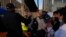 FILE - Ukrainian refugees speak with a U.S. Customs and Border Patrol official as they prepare to cross the border on April 4, 2022, in Tijuana, Mexico. The Biden administration on Aug. 18, 2023, announced an expansion of temporary legal status for Ukrainians living in the U.S.
