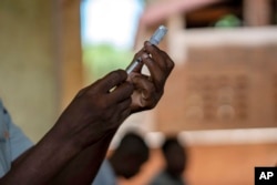 FILE - Health officials prepare to administer a vaccine in the Malawi village of Tomali with the world's first vaccine against malaria in a pilot program in Tomali, Dec. 11, 2019. (AP Photo/Jerome Delay, File)