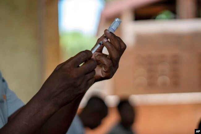 FILE - Health officials prepare to administer a vaccine in the Malawi village of Tomali with the world's first vaccine against malaria in a pilot program in Tomali, Dec. 11, 2019. (AP Photo/Jerome Delay, File)