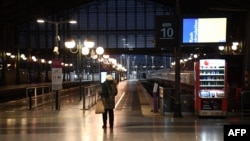 FILE - A traveler waits in front of platforms at Gare du Nord train station during nationwide strikes and protests against the government's pension reform plan, in Paris, France, Jan. 31, 2023.
