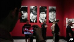 Seorang pengunjung mengambil gambar di pameran Paul McCartney Photographs 1963-64: Eyes of the Storm di Inggris (dok: AP)