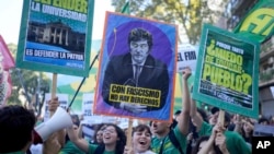 FILE - Students protest for more public university funding and against austerity measures proposed by President Javier Milei, featured on the sign, in Buenos Aires, Argentina, April 23, 2024.