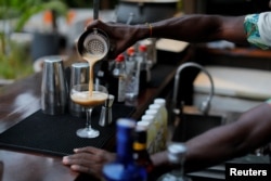 A mixologist prepares a glass of espresso martini at a bar in Accra, Ghana, February 21, 2023.