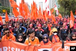 Aksi unjuk rasa memperingati Hari Buruh Internasional di Jakarta, Senin, 1 Mei 2023. (AP/Dita Alangkara)