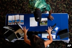 A woman talks to an attendee at the Black Health Matters Health Summit and Expo in New York, Thursday, Aug. 15, 2024. (AP Photo/Pamela Smith)