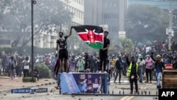Waandamanaji wakiwa wameshika bendera ya Kenya nje ya majengo ya bunge