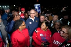 Presiden United Auto Workers (UAW) Shawn Fain berdiri bersama anggota UAW dalam aksi mogok di Pabrik Perakitan Ford Michigan di Wayne, Michigan, Jumat pagi, 15 September 2023. (AP/Paul Sancya)