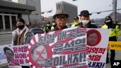 Manifestantes se reúnen para oponerse a la visita del presidente de Corea del Sur, Yoon Suk Yeol, a Japón, frente a la embajada de Estados Unidos en Seúl, el 16 de marzo de 2023. Los letreros dicen "Un traidor projaponés".
