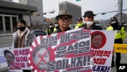 Protesters gather for a rally to oppose the visit of South Korean President Yoon Suk Yeol to Japan, in front of the US embassy in Seoul, March 16, 2023. The signs read "A pro-Japanese traitor."