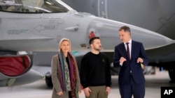Belgium's Prime Minister Alexander De Croo, right, and Belgium's Defense Minister Ludivine Dedonder, left, pose for a photo with Ukraine's President Volodymyr Zelenskyy in front of an F-16 at Melsbroek military airport near Brussels, May 28, 2024.