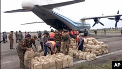 In this photo provided by Myanmar Military True News Information Team on Monday, May 15, 2023, soldiers and polices unload relief items for victims at airport after Cyclone Mocha in Sittwe township, Rakhine State, Myanmar.