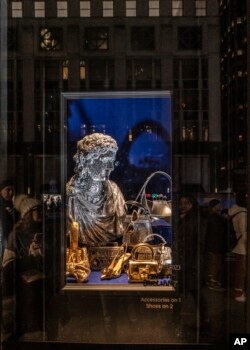 Pembeli dan pejalan kaki berjalan melewati etalase di Bergdorf Goodman di Fifth Avenue di New York, Kamis, 14 Desember 2023. (AP Photo/Peter K. Afriyie)