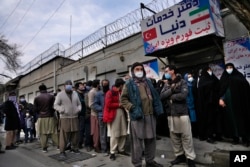 Warga Afghanistan antre di luar Kedutaan Besar Iran untuk mengajukan permohonan visa, di Kabul, Afghanistan, 13 February 2022. (Foto: Hussein Malla/AP Photo)