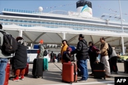 2024年1月1 日，乘客们在上海码头排队等候登上中国第一艘国产邮轮爱达·魔都号。（法新社）