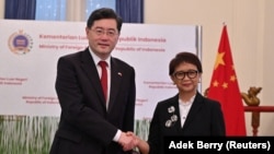 Menlu China Qin Gang berjabat tangan dengan Menlu Retno Marsudi saat sesi foto di Jakarta, 22 Februari 2023. (Foto: Adek Berry via REUTERS)