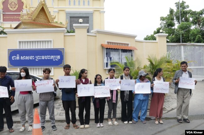 ក្រុមយុវជន និងអ្នកគាំទ្រសកម្មជនមាតាធម្មជាតិឈរលើកបដា នៅមុខសាលាដំបូងរាជធានីភ្នំពេញ នាថ្ងៃទី២៩ ខែឧសភា ឆ្នាំ២០២៤។ (ស៊ឹម ចាន់សំណាង/វីអូអេ)