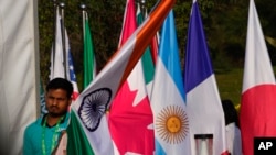 Radnik nosi indijsku nacionalnu zastavu kako bi je stavio uz zastave drugih zemalja učesnica na otvaranju sastanka ministara inostranih poslova G20, u Nju Delhiju, Indija, 2. marta 2023.