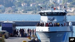 FILE - Migrants disembark from a Greek coast vessel after a rescue operation, at the port of Mytilene, on the northeastern Aegean Sea island of Lesbos, Greece, Aug. 28, 2023.