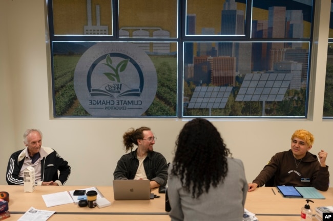 Student ambassadors Andrew Rodriguez, from right, Jaden Hugenberger and Jeff Kaisershot share a light moment at the California Center for Climate Change Education on the West Los Angeles College campus in Culver City, Calif., Tuesday, March 12, 2024. (AP Photo/Jae C. Hong)