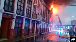 In this photo provided by Bomberos/ Ayuntamiento de Murcia, firefighters work outside a nightclub on fire in Murcia, south-eastern Spain, Oct. 1, 2023.